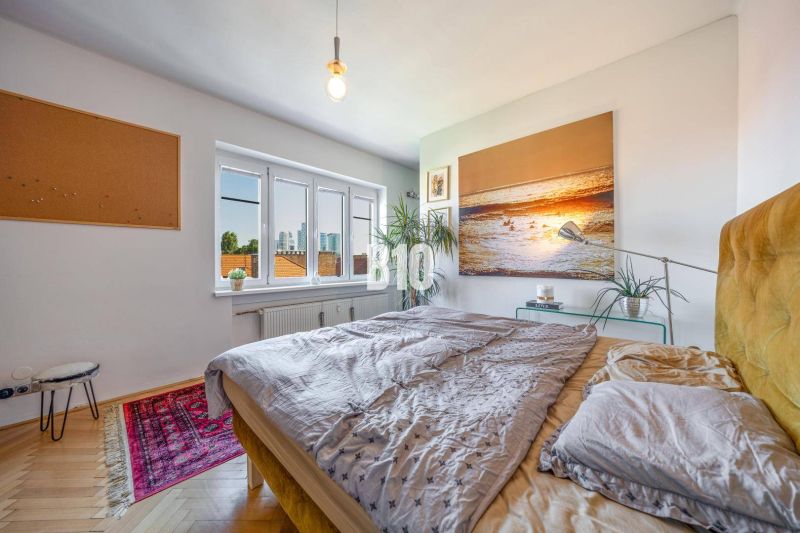 Prenájom | 2-izbový byt | Záhradnícka – Poľská ulica | 900 € + 200 € e - Spálňa v 2-izbovom byte s obrazom na stene a podlahou s dreveným dekorom.