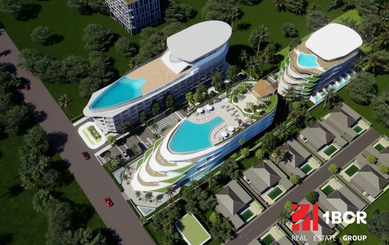 SOLE MIO RESIDENCES PHUKET - Vizualizácia výstavby bytov v Phukete: viacpodlažné budovy s bazénmi obklopené zeleňou a cestou.