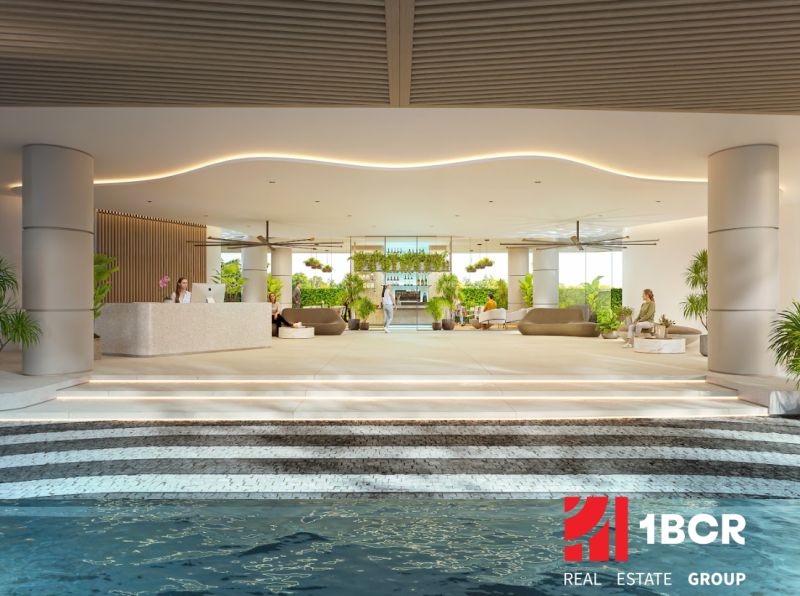 SOLE MIO RESIDENCES PHUKET - Interiér bytovej výstavby s recepciou a relaxačnou zónou, zdobené zeleňou a sedením.
