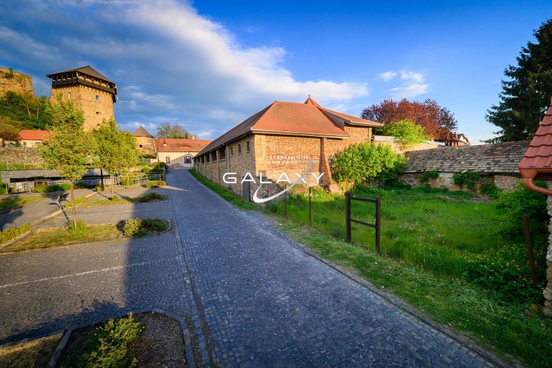 Pozemok v tesnej blízkosti hradu – Fiľakovo - Kamenný chodník vedúci popri historickej budove v Pozemkoch - komerčných vo Fiľakove.