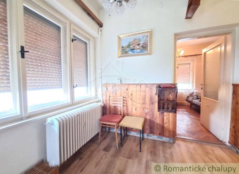 Priestranný pôvodný dom na rozľahlom pozemku v centre obce Gbelce - Interiér Rodinného domu s podlahou s dreveným dekorom a obrazom na stene.