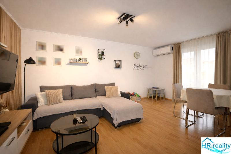 Vodice(HR)-Kompletne zariadený 3 izbový apartmán - Pohodlný obývací priestor v rekreačnom apartmáne s podlahou s dreveným dekorom a jedálenským stolom.