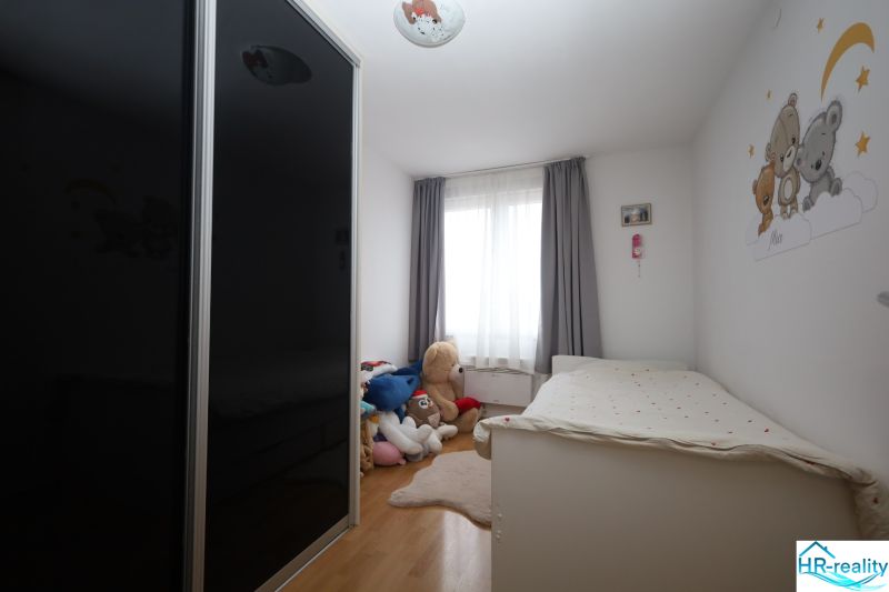 Vodice(HR)-Kompletne zariadený 3 izbový apartmán - Detská izba v Rekreačnom apartmáne s posteľou, skriňou a plyšovými hračkami na podlahe s dreveným dekorom.