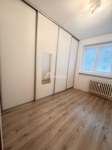PREDAJ: 3i s balk. 67 m2; Uhlisko-Banská Bystrica; 205.000 € - Izba v 3-izbovom byte s bielou skriňou a podlahou s dreveným dekorom.