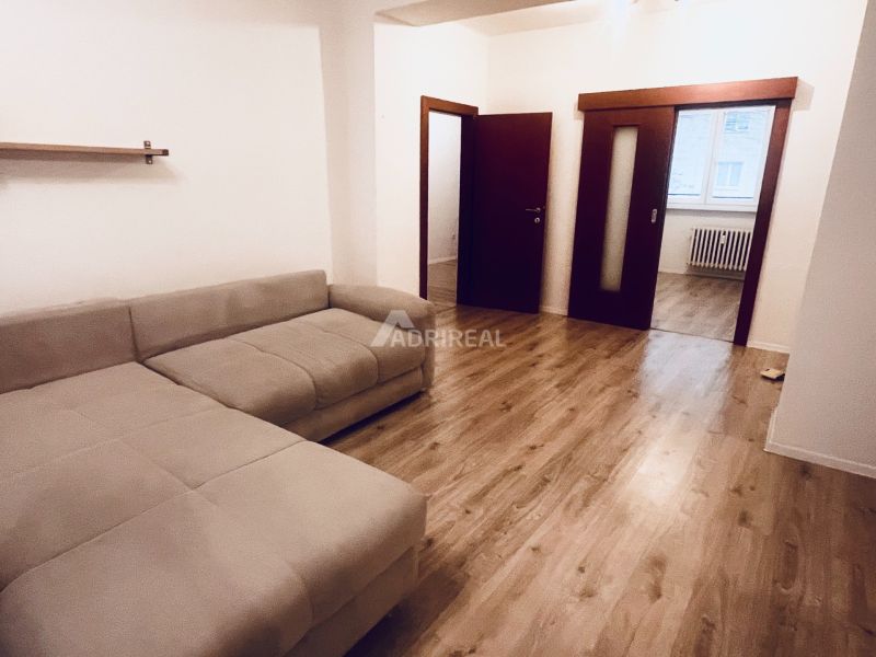 PREDAJ: 3i s balk. 67 m2; Uhlisko-Banská Bystrica; 205.000 € - Obývacia izba s pohodlnou sedačkou a podlahou s dreveným dekorom v 3-izbovom byte.