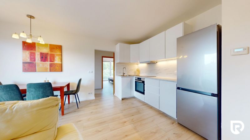 | Pekný a priestranný 3-izbový byt | 70m² |  - Kuchyňa a jedálenský priestor v 3-izbovom byte s podlahou s dreveným dekorom.