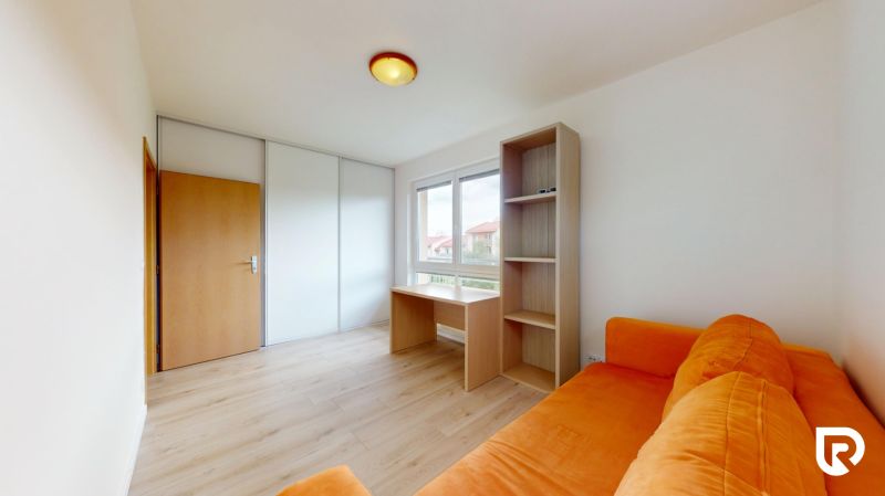 | Pekný a priestranný 3-izbový byt | 70m² |  - Izba v 3-izbovom byte so svetlým nábytkom, oranžovou sedačkou a podlahou s dreveným dekorom.