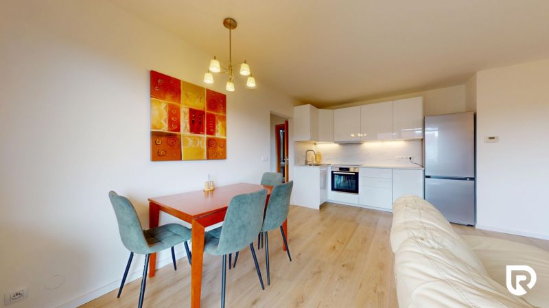 | Pekný a priestranný 3-izbový byt | 70m² |  - Kuchyňa s jedálenským stolom a podlahou s dreveným dekorom v 3-izbovom byte.