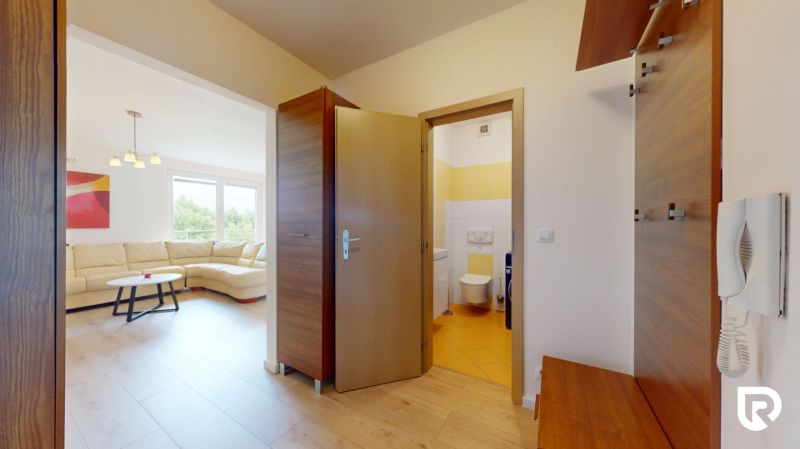 | Pekný a priestranný 3-izbový byt | 70m² |  - Interiér 3-izbového bytu s podlahou s dreveným dekorom, pohľad do obývacej izby.