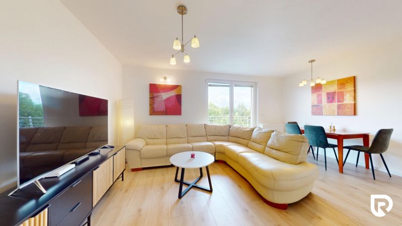 | Pekný a priestranný 3-izbový byt | 70m² |  - Obývacia izba s pohovkou, konferenčným stolíkom, jedálenským stolom a podlahou s dreveným dekorom.