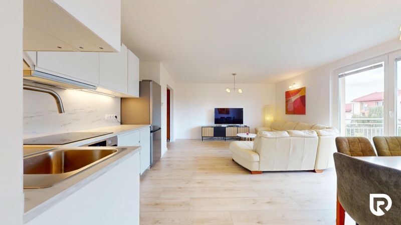 | Pekný a priestranný 3-izbový byt | 70m² |  - Otvorená obývacia izba s kuchyňou a podlahou s dreveným dekorom, 3-izbový byt.