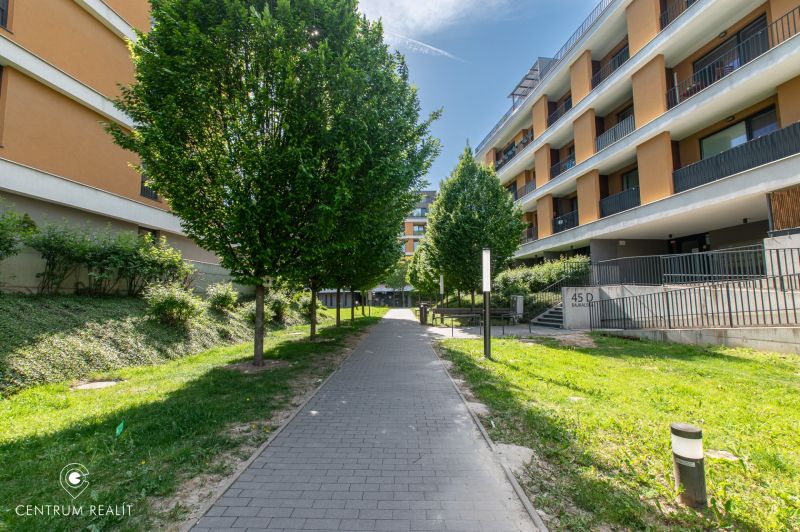 Moderný 2-izbový apartmán s parkovaním, Vila Leonardo, Bajkalská - Bajkalská ulica v Bratislave s bytovými domami a stromami popri chodníku.