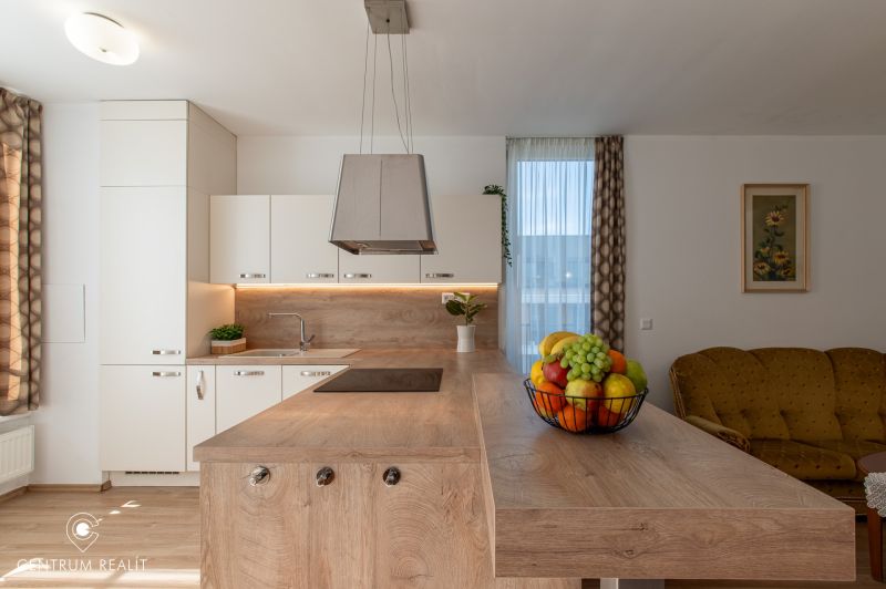 Moderný 2-izbový apartmán s parkovaním, Vila Leonardo, Bajkalská - Kuchyňa s ostrovčekom a ovocím v 2-izbovom byte, podlaha s dreveným dekorom.