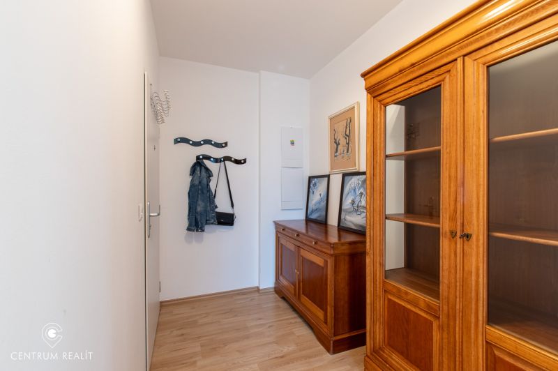 Moderný 2-izbový apartmán s parkovaním, Vila Leonardo, Bajkalská - Interiér 2-izbového bytu s dreveným nábytkom a podlahou s dreveným dekorom.