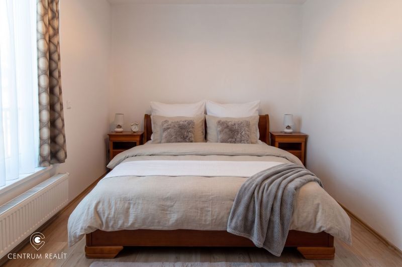Moderný 2-izbový apartmán s parkovaním, Vila Leonardo, Bajkalská - Spálňa s lôžkom a dreveným nábytkom v 2-izbovom byte, podlaha s dreveným dekorom.