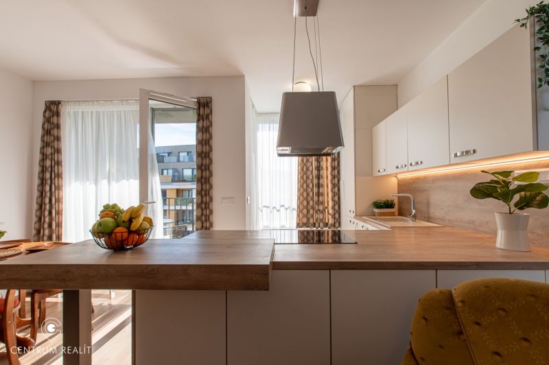 Moderný 2-izbový apartmán s parkovaním, Vila Leonardo, Bajkalská - Kuchyňa v 2-izbovom byte s otvoreným balkónom a dekorom drevenej podlahy.