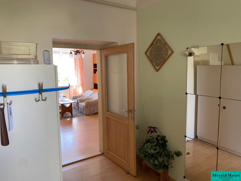 Byt na rekonštrukciu v centre Bratislavy – výborný projekt - Interiér 2-izbového bytu s podlahou s dreveným dekorom, viditeľná obývacia miestnosť.