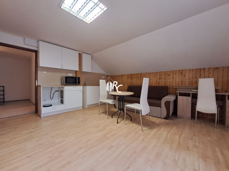 NA PRENÁJOM 3 izbový byt v rodinnom dome Martin Sever - Poddrovný apartmán s kuchyňou, podlahou s dreveným dekorom a jedálenským stolom v 3-izbovom byte.