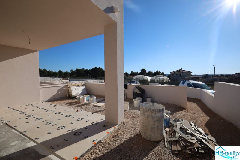 Vodice(HR)-3-izbový byt 81 m2 so záhradou - Stavebné práce na terase rekreačného apartmánu vo Vodiciach, slnečný deň, viditeľné nádoby a materiál.
