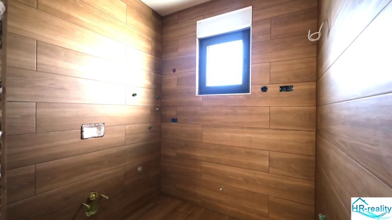 Vodice(HR)-3-izbový byt 81 m2 so záhradou - Rekreačný apartmán s obkladmi v drevenom dekore a malým oknom.
