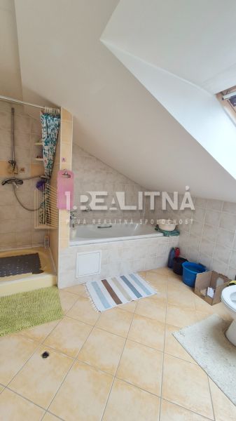 POSCHODOVÝ RODINNÝ DOM V PODKONICIACH, 300M2 - Kúpeľňa v rodinnom dome s vaňou, sprchou a šikmým stropom.