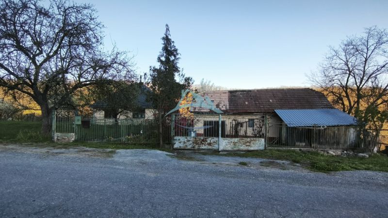 RD (pozemok 9756 m2)  v osade Prieloh, okr. V. Krtíš. - Rodinný dom na ulici Prieloh v Muli so starou strechou a bránou.