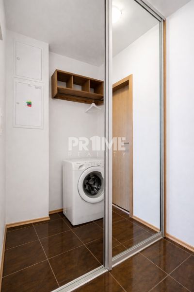 Slnečný 2i byt s loggiou, garáž, pivnica, novostavba, Stromová-Kramáre - Práčka a zrkadlová skriňa v 2-izbovom byte s dlažbou, drevený dekorový nábytok.