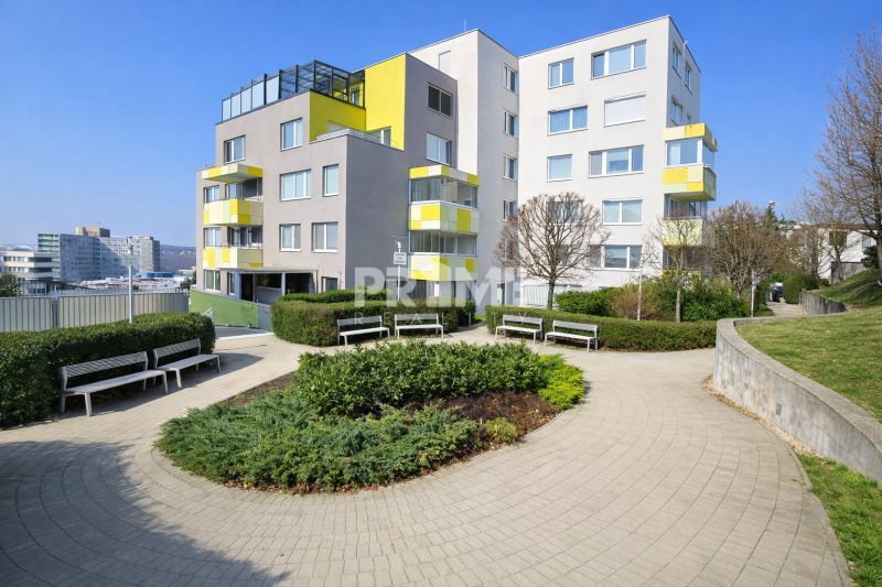 Slnečný 2i byt s loggiou, garáž, pivnica, novostavba, Stromová-Kramáre - Bytový dom v Bratislave - Novom Meste na Stromovej ulici, obklopený zeleňou a lavičkami.