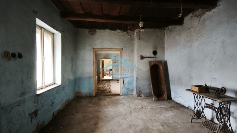 RD na rekonštrukciu na ul Tučekova vo V. Krtíši. - Izba v rodinnom dome s modrými stenami, starým šijacím strojom a dreveným korýtkom.