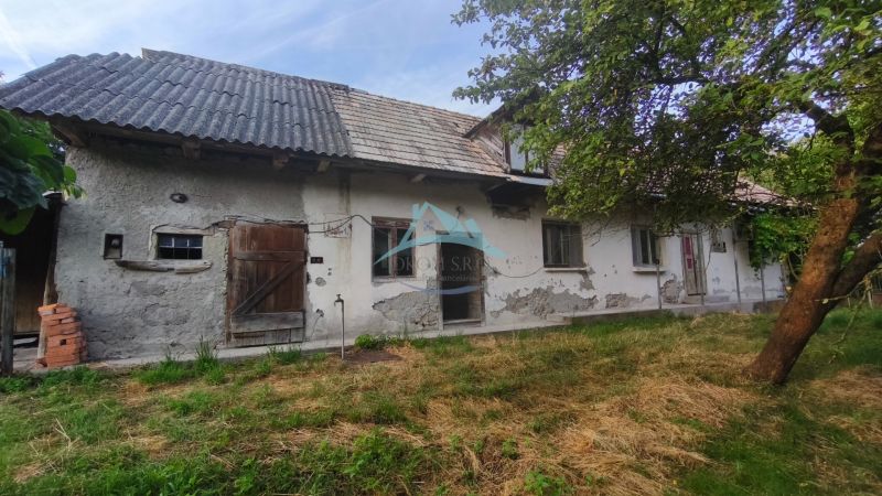 Kamenný vidiecky dom v obci Čelovce okres Veľký Krtíš. - Rodinný dom v Čelovciach s opotrebovanou omietkou, drevenými dverami a záhradou.