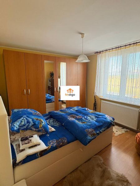 PREDAJ - Rodinný dom s veľkým pozemkom – Nitra, Lužianky  - Spálňa v rodinnom dome s drevenou skriňou a modrými posteľnými obliečkami.