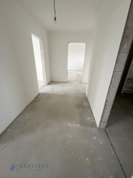 Na predaj 3 izb. byt s balkónom blízko centra - Prázdna miestnosť s bielymi stenami v 3-izbovom byte, dvere vedú do ďalších izieb.