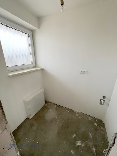 Na predaj 3 izb. byt s balkónom blízko centra - Prázdna miestnosť v 3-izbovom byte s oknom a zásuvkami, betónová podlaha.