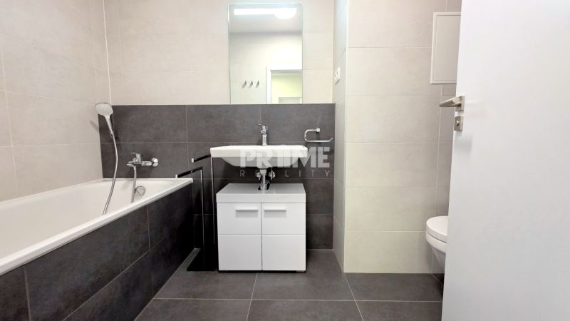 MODERNÝ 2i byt, POD VINICOU, LOGGIA, PARKING, Nové Mesto - Kúpeľňa v 2-izbovom byte s vaňou, umývadlom a bielym nábytkom.