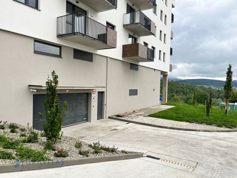 Prenájom kancelárskych / obchodných priestorov s terasou - Bytový dom s balkónmi, zeleňou a parkovaním v Považskej Bystrici, kancelárie v pozadí.