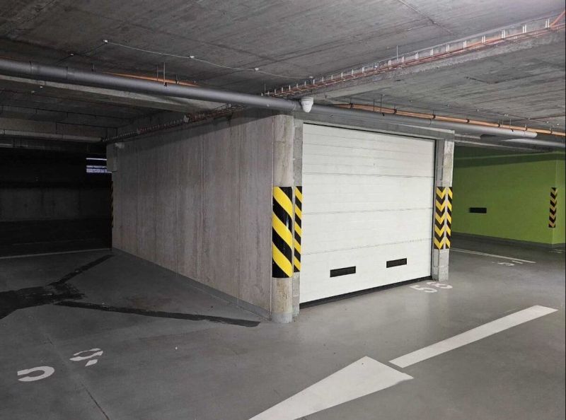 PREDAJ -  Garáž  na ulici Údernícka - Garáže na Úderníckej ulici v Bratislave - Petržalke s betónovými stenami a rolovacou bránou.