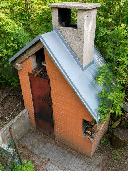 Rekreačná chata s pozemkom a panoramatickým výhľadom - Ovocinár - Malá tehlová chata na Ovocinárskej ulici v Stupave, obklopená bujnou zeleňou.