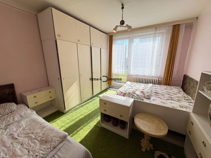 Na predaj: 2 izb.byt v CENTRE mesta + 2x BALKÓN, ŠATNÍK, PIVNICA - Spálňa v 2-izbovom byte s dvojposteľou, vstavanou skriňou a zeleným kobercovým dekorom.