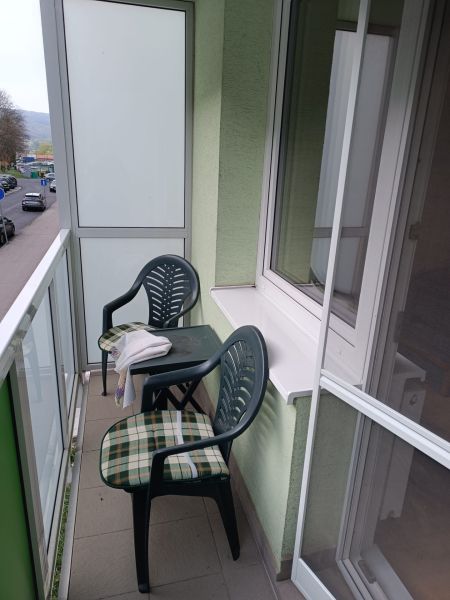 Na prenájom  veľkometrážny 3 izbový byt Nová Baňa - Balkón 3-izbového bytu na Školskej ulici v Novej Bani so stolíkom a stoličkami.
