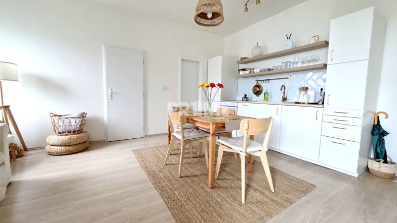 ŠTÝLOVÝ 2i BYT, REKONŠTRUKCIA, BALKÓN, KLÍMA, Murgašová ulica - Jedálenský kút s kuchyňou v 2-izbovom byte, podlaha s dreveným dekorom.