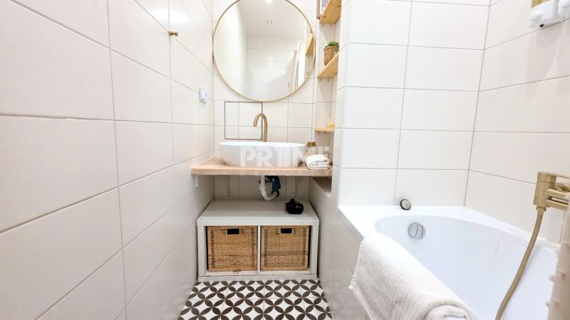 ŠTÝLOVÝ 2i BYT, REKONŠTRUKCIA, BALKÓN, KLÍMA, Murgašová ulica - Kúpeľňa so zlatým kohútikom, okrúhlym zrkadlom a úložnými košmi v 2-izbovom byte.
