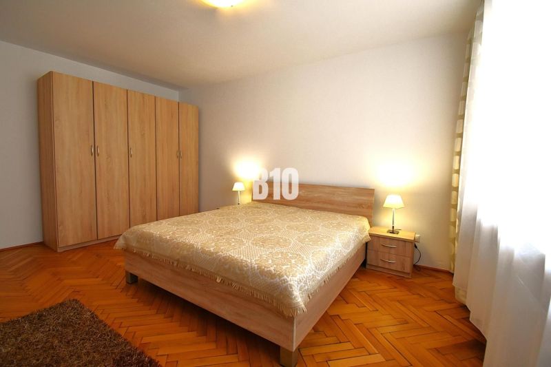 NA PRENÁJOM Priestranný 3 izbovy byt Žilina  - centrum mesta , FOR REN - Spálňa v 3-izbovom byte s manželskou posteľou, skriňou a lampami, podlaha s dreveným dekorom.