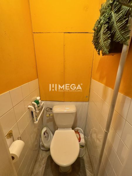 PREDANÉ- 2 izbový byt s balkónom blízko centra mesta Humenné - Toaleta v 2-izbovom byte s jasnou žltou stenou a zelenou dekoráciou.