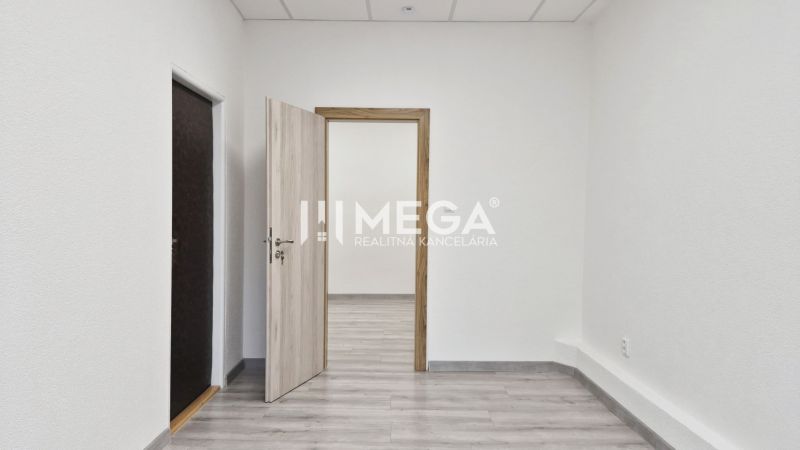PRENÁJOM komerčného priestoru (26 m2) blízko centra Humenné - Interiér obchodných priestorov s bielymi stenami a podlahou s dreveným dekorom.