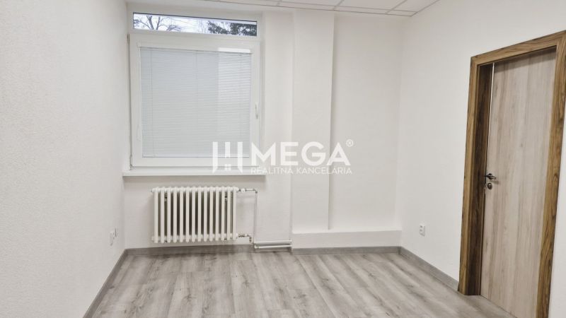 PRENÁJOM komerčného priestoru (26 m2) blízko centra Humenné - Interiér obchodných priestorov s bielymi stenami, oknom a podlahou s dreveným dekorom.