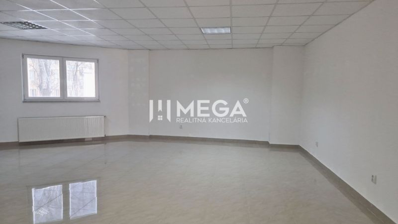 PRENÁJOM obchodného priestoru v centre Humenného (74 m2) - Obchodné priestory s dlažbou, biele steny a veľkými oknami.
