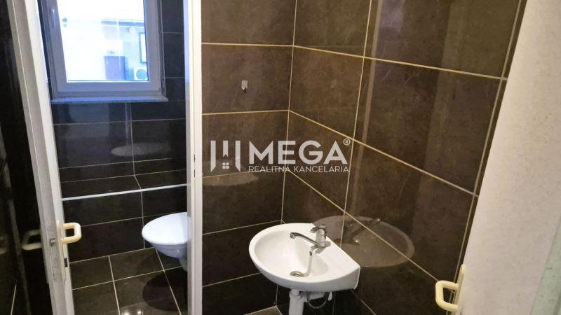 PRENÁJOM obchodného priestoru v centre Humenného (74 m2) - Kúpeľňa v obchodných priestoroch s tmavým obkladom a umývadlom.