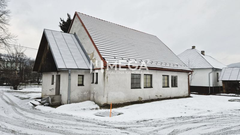 Predaj budovy v obci Zboj - Snehom pokryté obchodné priestory v obci Zboj s tradičnou architektúrou a strechou.
