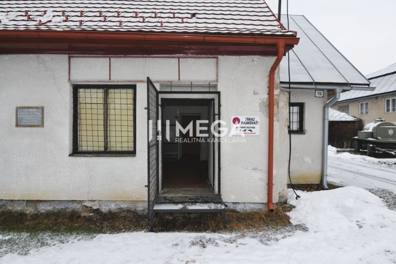 Predaj budovy v obci Zboj - V Zboji sú obchodné priestory s otvorenými dverami, mriežkovaným oknom a nápisom 