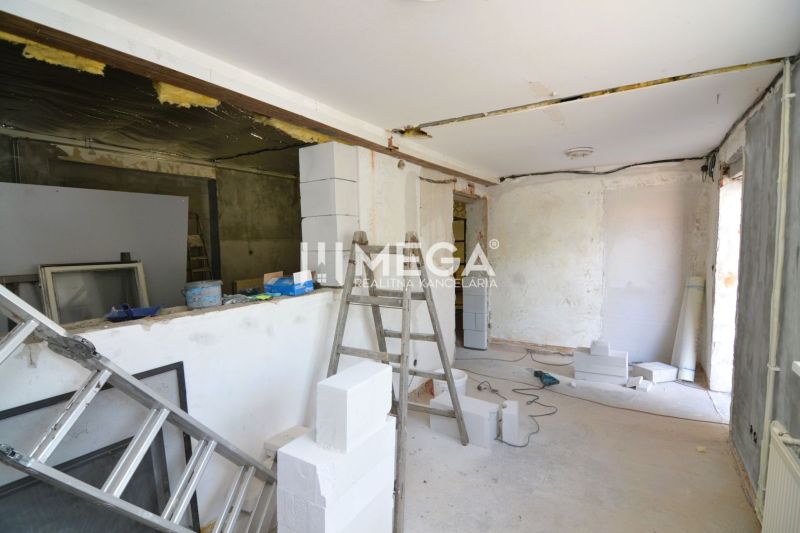 PRENÁJOM PRIESTORU PRE VÝROBU alebo SKLAD HUMENNÉ ulica Sninská - Výrobné priestory vo výstavbe s rebríkom a stavebným materiálom, podlaha s dreveným dekorom.